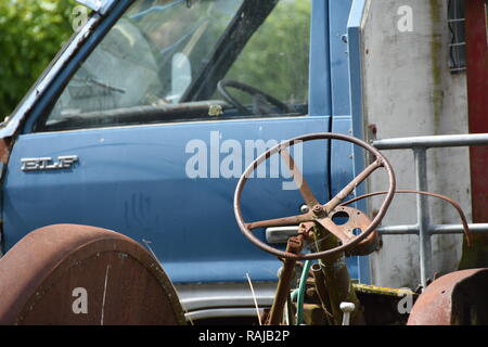 Van e il trattore in un piccolo cantiere di demolizione accanto a un vigneto Foto Stock