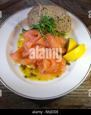 Salmone affumicato servita con pane integrale e spicchi di limone. Il salmone è scozzese.