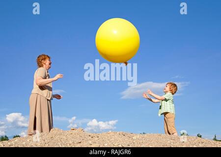 Madre e figlio giocando con una grande mongolfiera Foto Stock