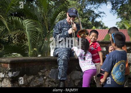 (Feb. 6, 2017) puerto barrios, Guatemala - musicista di terza classe Ryan Miller, nativo di Port Huron, Mich, attaccato alla U.S. Le forze della flotta Band, Norfolk, Virginia, riproduce il trombone per la nazione ospitante i bambini durante una visita a un orfanotrofio a sostegno di continuare promessa 2017's (CP-17) visita a Puerto Barrios, Guatemala. CP-17 è un U.S. Comando sud-sponsorizzato e U.S. Forze Navali Comando meridionale/STATI UNITI 4a flotta-condotto di distribuzione condotta civile-militare comprendente le operazioni di assistenza umanitaria, impegni di formazione e medico, dentista e supporto di veterinari in uno sforzo per mostrare U.S. sup Foto Stock