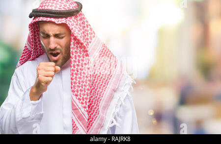 Giovane uomo bello indossare keffiyeh su sfondo isolato senso di malessere e tosse come sintomo per il freddo o la bronchite. Il concetto di assistenza sanitaria. Foto Stock