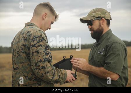 Shaun Sorensen, a destra una piccola Unmanned Aerial istruttore dei sistemi di formazione e di supporto logistico attività, incarica un Marine con la Task Force di sud-ovest sul controlli adeguati per la immediata SUAS Occhio di Camp Lejeune, N.C., Febbraio 8, 2017. L'istante occhio è il primo drone in Marine Corps' repertorio che può avviare e terra senza una pista o personale di assistenza. Circa 300 Marines sono assegnati alla Task Force sud-ovest, la cui missione sarà quella di treno, consigliare e assistere l'Esercito nazionale afgano 215th Corps e zona 505th della polizia nazionale. Foto Stock