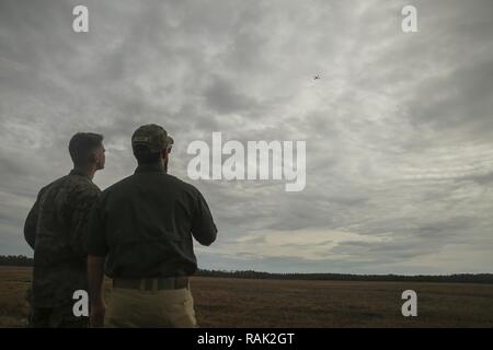 Shaun Sorensen, a destra una piccola Unmanned Aerial istruttore dei sistemi di formazione e di supporto logistico, di attività e di un Marine con la Task Force a sud-ovest, sinistra, volare l'occhio istantanea SUAS a Camp Lejeune, N.C., Febbraio 8, 2017. L'occhio istantanea è rivoluzionario in quanto è in grado di volare facilmente in edifici, sulle pareti e sulle colline ed è in grado di decollare e atterrare verticalmente. Circa 300 Marines sono assegnati alla Task Force sud-ovest, la cui missione sarà quella di treno, consigliare e assistere l'Esercito nazionale afgano 215th Corps e zona 505th della polizia nazionale. Foto Stock