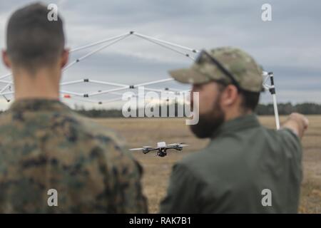 Shaun Sorensen, a destra una piccola Unmanned Aerial istruttore dei sistemi di formazione e di supporto logistico attività, incarica un Marine con la Task Force a sud-ovest, a sinistra su manovre di volo dell'occhio istantanea SUAS a Camp Lejeune, N.C., Febbraio 8, 2017. L'occhio istantanea è rivoluzionario in quanto è in grado di volare facilmente in edifici, sulle pareti e sulle colline ed è in grado di decollare e atterrare verticalmente. Circa 300 Marines sono assegnati alla Task Force sud-ovest, la cui missione sarà quella di treno, consigliare e assistere l'Esercito nazionale afgano 215th Corps e zona 505th della polizia nazionale. Foto Stock