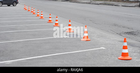 Parcheggio auto e arancio cono di traffico. Chiuso parcheggio auto con contrassegno bianco e cono del traffico su strada utilizzata segno di avvertimento sulla strada Foto Stock