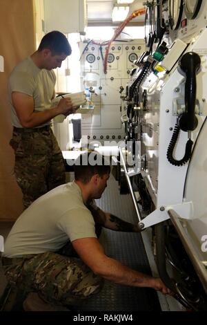 Recuperare diver Spc. Nathaniel Marquez (retro) e Sgt. Christopher Miller, entrambi con ingegnere 511th Dive distacco fuori di Fort Eustis, Virginia, eseguire i controlli di manutenzione su una marina Standard Double Lock Camera di ricompressione System in Kuwait Base Navale, Kuwait, Feb 02, 2017. La verifica di mantenimento è in preparazione della formazione soldati nel funzionamento della camera, soldato avanzamento e per contribuire a un soldato con un pregiudizio subito durante un precedente esercizio. Foto Stock