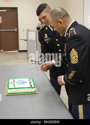 Sgt. Christopher Ruff del 321gli affari civili brigata (sinistra) e il comando Sgt. Il Mag. Steven Santiago del 350Affari Civili del comando (a destra) tagliare una fetta di torta durante una cerimonia di premiazione come parte del guerriero migliore concorrenza nel Camp Bullis, Texas, nel febbraio 12, 2017. BWC è un evento annuale che le prove dei soldati set di abilità attraverso molteplici sfide, culminanti essenzialmente in una scheda Aspetto. Foto Stock