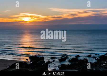 I surfisti al tramonto su Fistral Beach, Newquay, Cornwall, Regno Unito Foto Stock