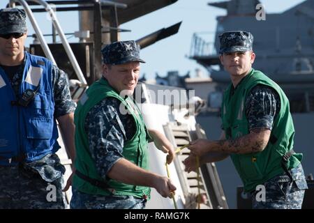 (16 febbraio 2017) i membri della USS Texas (SSN 775) maniglia la linea di ritorno alla porta dopo le operazioni di routine in mare Feb 16, 2017. Foto Stock