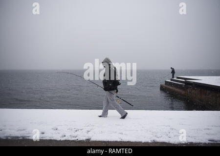 Salonicco, Grecia. 4 gennaio, 2019. Un pescatore passeggiate durante una nevicata presso il lungomare di Salonicco. Gli ultimi giorni in Grecia è stata colpita da un cattivo tempo onda, come la neve continua a causare problemi in tutta la Grecia. Credito: Giannis Papanikos/ZUMA filo/Alamy Live News Foto Stock