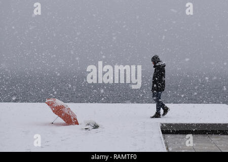 Salonicco, Grecia. 4 gennaio, 2019. Un uomo cammina durante una nevicata presso il lungomare di Salonicco. Gli ultimi giorni in Grecia è stata colpita da un cattivo tempo onda, come la neve continua a causare problemi in tutta la Grecia. Credito: Giannis Papanikos/ZUMA filo/Alamy Live News Foto Stock