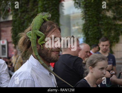 Kiev, Ucraina. 25 Maggio, 2018. Un uomo con un iguana sulla sua testa . vedere a piedi giù per la strada. Credito: Sergei Chuzavkov SOPA/images/ZUMA filo/Alamy Live News Foto Stock