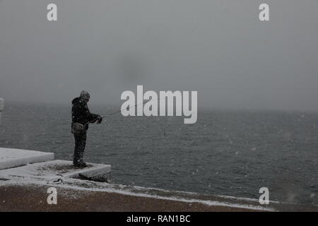 Salonicco, Grecia. 4 gennaio, 2019. Un uomo è visto la pesca nella neve in Salonicco, Grecia, gen. 4, 2019. Molte parti del paese sono stati colpiti da un freddo estremo a scatto e la nevicata di recente a causa di una bassa pressione di sistema meteo denominato 'Sophia'. Nella città settentrionale di Salonicco, due voli internazionali sono stati annullati e cinque sono state deviate verso altri aeroporti greci giovedì, le autorità locali hanno annunciato. Credito: Lefteris Partsalis/Xinhua/Alamy Live News Foto Stock