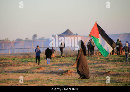 Una donna Palestinese visto tenendo una bandiera della Palestina durante la protesta. Manifestazioni tra i cittadini palestinesi e forze di occupazione israeliane nel corso di una protesta contro il riconoscimento del Presidente americano Trump Gerusalemme come capitale di Israele ha rifiutato il blocco del nord della Striscia di Gaza. Foto Stock