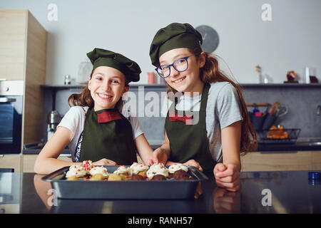 Ragazze bambini in cook divise in cucina. Foto Stock