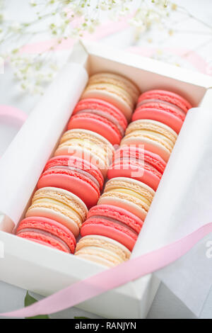 Corallo e torte beige macarons o amaretti in una scatola regalo bianca. Il concetto di giorno di San Valentino e la molla è in festa. Foto Stock