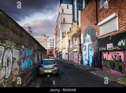 Un moody scena del vicolo della troncatrice Street, Liverpool con un John Lennon murale e altri graffiti. Foto Stock