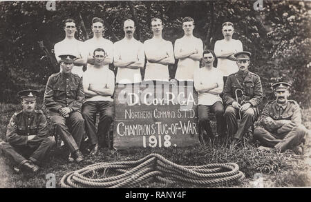Vintage Cartolina fotografica che mostra British WW1 soldati. La 'D' Coy, R.G.A. Comando Nord S.T.D. Il Tug-of-War Champions 1918. Foto Stock