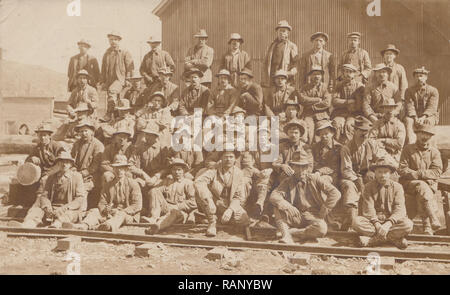 Vintage Cartolina fotografica che mostra un gruppo di i lavoratori del settore ferroviario. Foto Stock