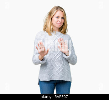 Giovane e bella donna che indossa un maglione invernale su sfondo isolato disgustato espressione, orinato e timorosi facendo il disgusto di fronte perché avversione Foto Stock