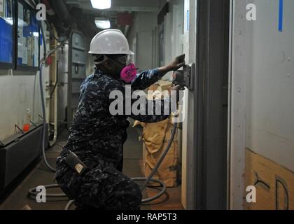 YOKOSUKA, Giappone (feb. 22, 2017) - Ospedale Corpsman 3rd Class Patrick Gayle da Jacksonville, Florida, fissato per gli Stati Uniti 7 ammiraglia della flotta USS Blue Ridge (LCC 19), sabbie un telaio della porta in nave del medico di area di attesa. Blue Ridge è in un esteso intervallo di manutenzione al fine di modernizzare la nave di continuare a servire come una robusta piattaforma di comunicazione negli Stati Uniti 7 flotta area di operazioni. Foto Stock