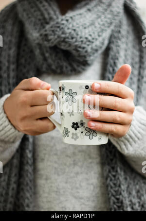 Tazza di una bevanda calda in bambini con le mani in mano Foto Stock