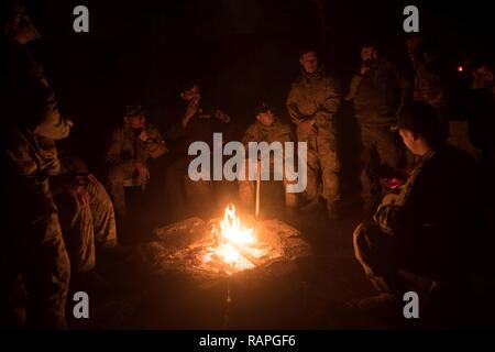 Stati Uniti I soldati dell esercito assegnati al 2° Battaglione, 325Airborne Reggimento di Fanteria, 2° Brigata Team di combattimento, ottantaduesima Airborne Division e irachena contro il terrorismo i soldati del servizio sit dal fuoco in una località segreta in Iraq, Feb 23, 2017. Una coalizione globale di più di 60 regionali e internazionali hanno delle nazioni unite insieme per consentire a partner le forze per sconfiggere ISIS. CJTF-funzione OIR è la coalizione globale per sconfiggere ISIS in Iraq e la Siria. Foto Stock