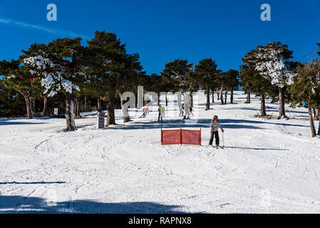 Navacerrada, Spagna - 7 Dicembre 2017: sciatori sci in discesa nella stazione sciistica di Guadarrama mountain range in inverno una giornata soleggiata con cielo blu Foto Stock