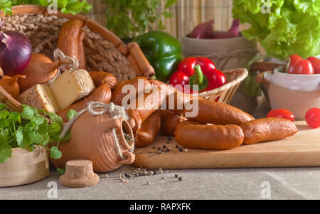 Salsicce bavarese con verdi e verdure su un tavolo da cucina. Foto Stock