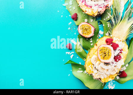 Gustoso frullato di appetitosi bocce servita in metà ananas decorato con taglio frutto della passione, scaglie di noce di cocco e semi di chia.la vita sana pulire mangiare co Foto Stock