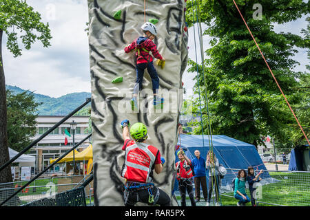 Istruttore maschio lavora con un giovane ragazzo sulla parete di arrampicata Foto Stock