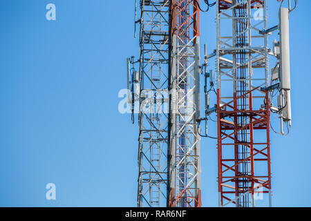 La Comunicazione Primo piano torre telaio in metallo isolato sul cielo blu. Foto Stock