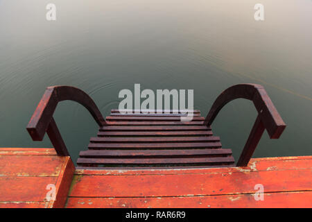 Acqua di acciaio stair, una scalinata che conduce all'acqua (come ad una barca sbarco) con calma naturale acqua superficie dello sfondo. Il riposo, il relax, acqua Activiti Foto Stock