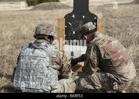 Pfc. Davion Williams, sinistra, 504th Intelligenza militare brigata risorse umane, riceve indicazioni da Staff Sgt. Manuel Sanchez dopo azzeramento, Dic 12, 2018 Fort Hood, Texas. I soldati che hanno zero le loro armi necessario sparare cinque dei sei round entro un certo diametro. Foto Stock