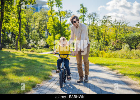 Padre insegna a suo figlio un giro in bicicletta Foto Stock