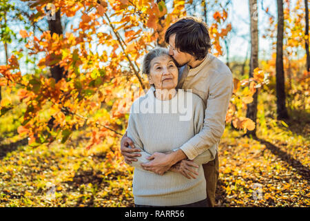 Nonna e nipote di adulti abbracciando in autunno park Foto Stock