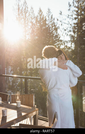 Giovane che abbraccia ogni altra nel balcone Foto Stock