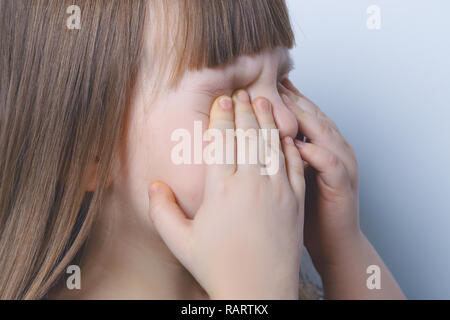 Una bambina è il pianto e strofinando gli occhi con le mani. Bambini Foto Stock