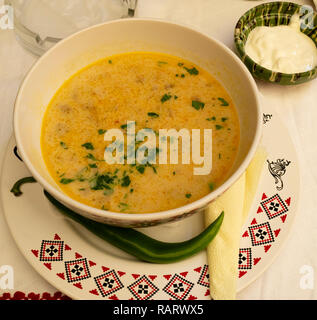 Un rumeno zuppa di mais con panna acida sul lato Foto Stock