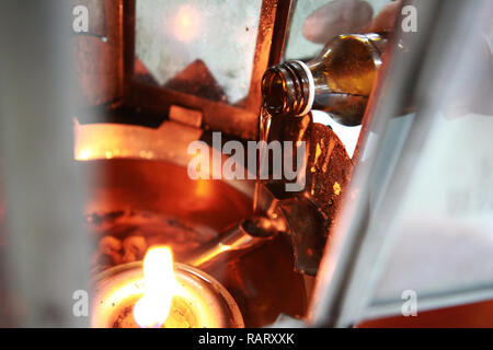 Buddisti di rendere merito,l'olio riempire in una lampada per l'illuminazione e per l'uso nell'incenso. Mezzi per rendere la vita senza intoppi. Messa a fuoco selettiva. Foto Stock