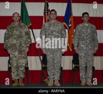 Brig. Gen. Wallace Turner (sinistra) sorge a attenzione mentre gli ordini di promozione vengono lette per la Larson fratelli presso l'esercito aviazione centro di fattibilità sulla base di comune accordo Lewis-Mc, 11 febbraio, 2017. Noel Larson (centro) è promosso Chief Warrant Officer cinque mentre suo fratello Justin (destra) Larson è promosso Chief Warrant Officer 4. Foto Stock
