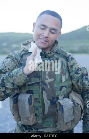 Stati Uniti Marine Corps Sgt. Carlos Ortiz con banda di Marino San Diego, Service Company, Headquartes e battaglione di servizio salviette camuffamento di vernice dal suo volto al Marine Corps Air Station Miramar, California, 16 febbraio, 2017. Ortiz pulito il suo viso dopo la conclusione del servizio Società Super Squad la concorrenza. Foto Stock