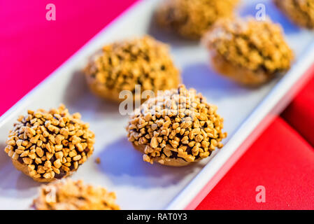 Piccole torte al cioccolato con i dadi sulla piastra stretta Foto Stock