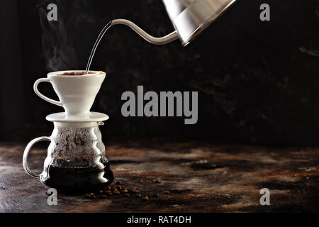 Facendo versare il caffè con acqua calda versata da un bollitore Foto Stock