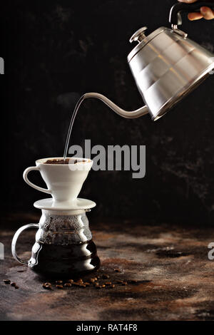 Facendo versare il caffè con acqua calda versata da un bollitore Foto Stock