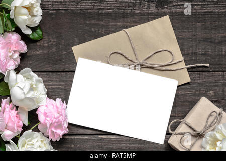 Branding elegante mockup per visualizzare le tue opere. vintage wedding greeting card con rosa e rose bianche e confezione regalo mock up su sfondo di legno. m Foto Stock