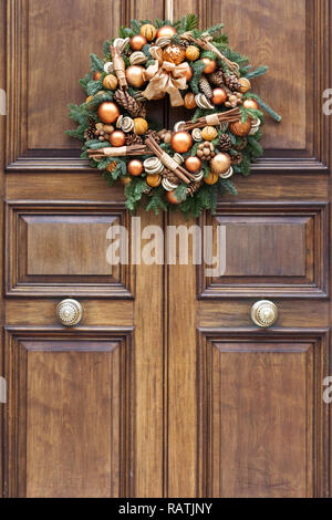 Natale decorativi ghirlande consegna su una porta anteriore a Londra Foto Stock