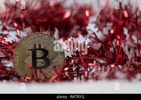 Bitcoin cryptocurrency moneta fisica posto accanto a ghirlanda di Natale decorazioni. Macro shot. Foto Stock