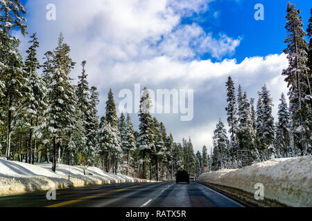 Viaggiando su una strada tortuosa attraverso la Sierra Mountains su una giornata invernale Foto Stock