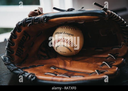 London, Regno Unito - 3 Gennaio 2019: Close up di un bianco palla da baseball all'interno di tan Guanto baseball. Originari in Inghilterra nel XVIII secolo, baseball è un ampiamente Foto Stock